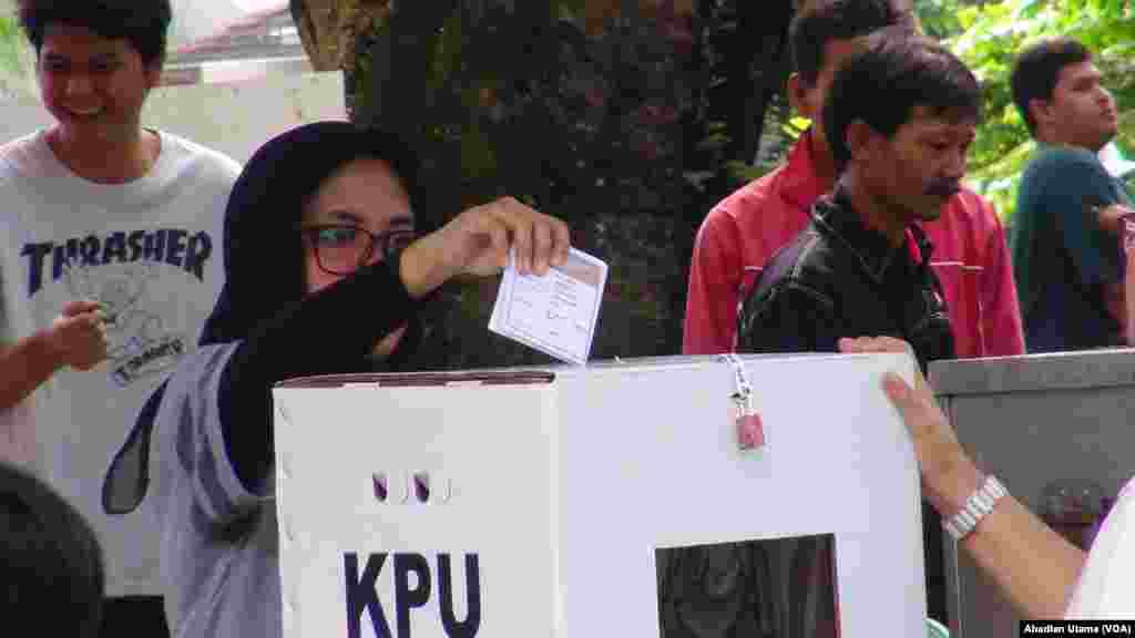 Seorang warga memasukan kertas suara ke kotak suara yg tersedia usai mencoblos di TPS 01 Cibinong, Kab. Bogor, 27 Juni 2018. (Foto: Ahadian Utama/VOA)