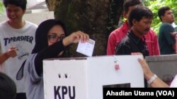 Seorang warga memasukan kertas suara ke kotak suara yg tersedia usai mencoblos di TPS 01 Cibinong, Kab. Bogor, 27 Juni 2018. (Foto: Ahadian Utama/VOA)