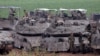 Israeli army troops stand around their tanks in an area along the border with the Gaza Strip in southern Israel on April 10, 2024, amid the ongoing conflict in the Palestinian territory between Israel and the militant group Hamas. (Photo by JACK GUEZ / AF