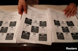 A staff member prepares leaflets of election campaign pledges before a news conference by Tokyo Governor Yuriko Koike, head of Japan's Party of Hope, for it's unveiling in Tokyo, October 6, 2017.