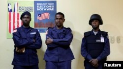 FILE - Police officers stand guard at National Election Commission headquarters in Monrovia, Liberia, Oct. 11, 2017. 