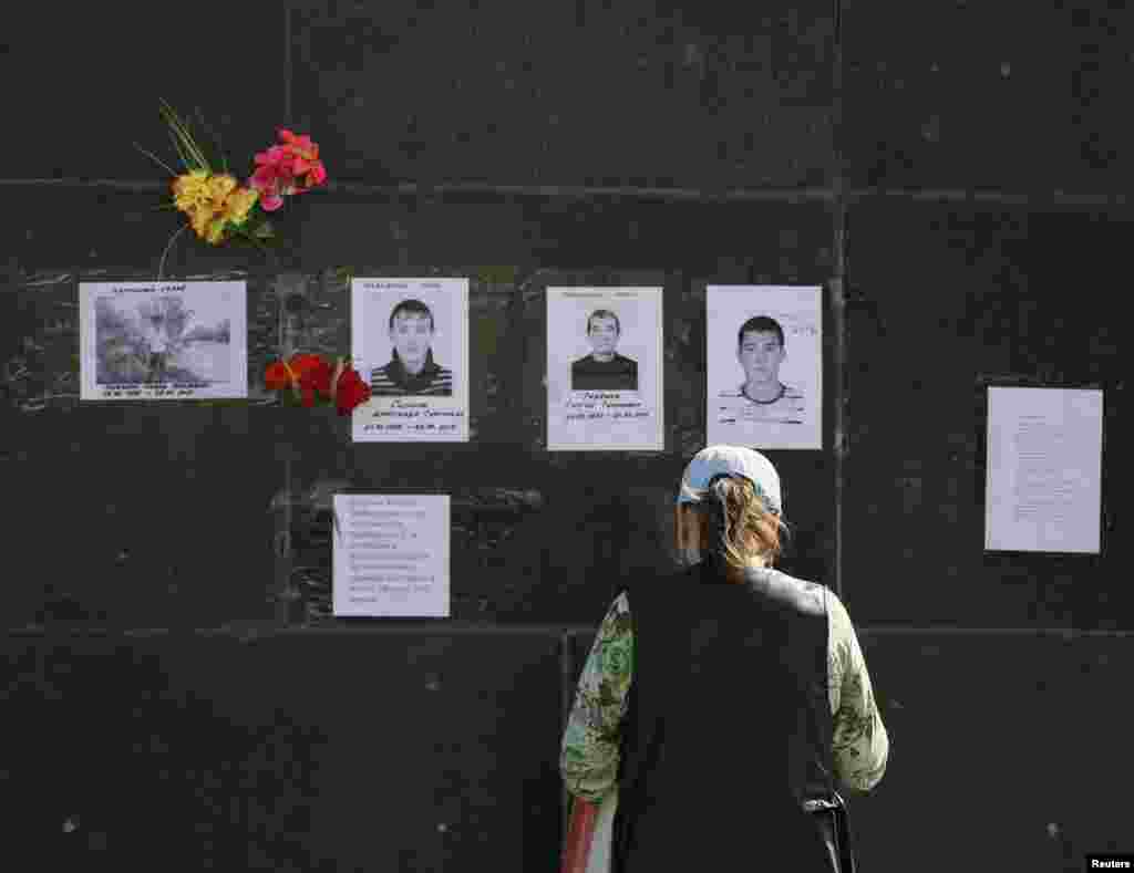 A woman looks at portraits of local residents killed in a gunfight, in Slovyansk, April 28, 2014.
