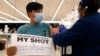 Lucas Kittikamron-Mora, de 13 años, muestra un cartel en apoyo a la vacuna contra el COVID-19 mientras recibe su primera dosis de Pfizer en el Departamento de Salud Pública del condado Cook, el 13 de mayo de 2021 en Des Plaines, Illinois. 