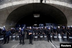 Police officers watch as hundreds of thousands of demonstrators press demands for wholesale democratic change in Algiers, Algeria, April 19, 2019.