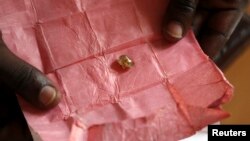 Un homme montre un diamant provenant de la région de Boda, en vente à Bangui, Centrafrique, le 1er mai 2014. 