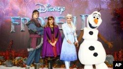 Character actors Kristoff, Anna, Elsa and Olaf pose for photographers upon arrival at the European premiere of "Frozen 2" in central London, Nov. 17, 2019.
