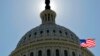 FILE - The U.S. flag flies next to the Capitol in Washington, as Congress and the Obama Administration continue work to raise the debt ceiling.