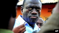 FILE - Ugandan opposition leader Kizza Besigye speaks to journalists, May 19, 2011, outside his house shortly after returning home after a confrontation with police, in Kasangati, Uganda. 