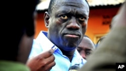 Kizza Besigye speaks to journalists, May 19, 2011, in the yard outside his house shortly after returning home after a confrontation with police, in Kasangati, Uganda. 