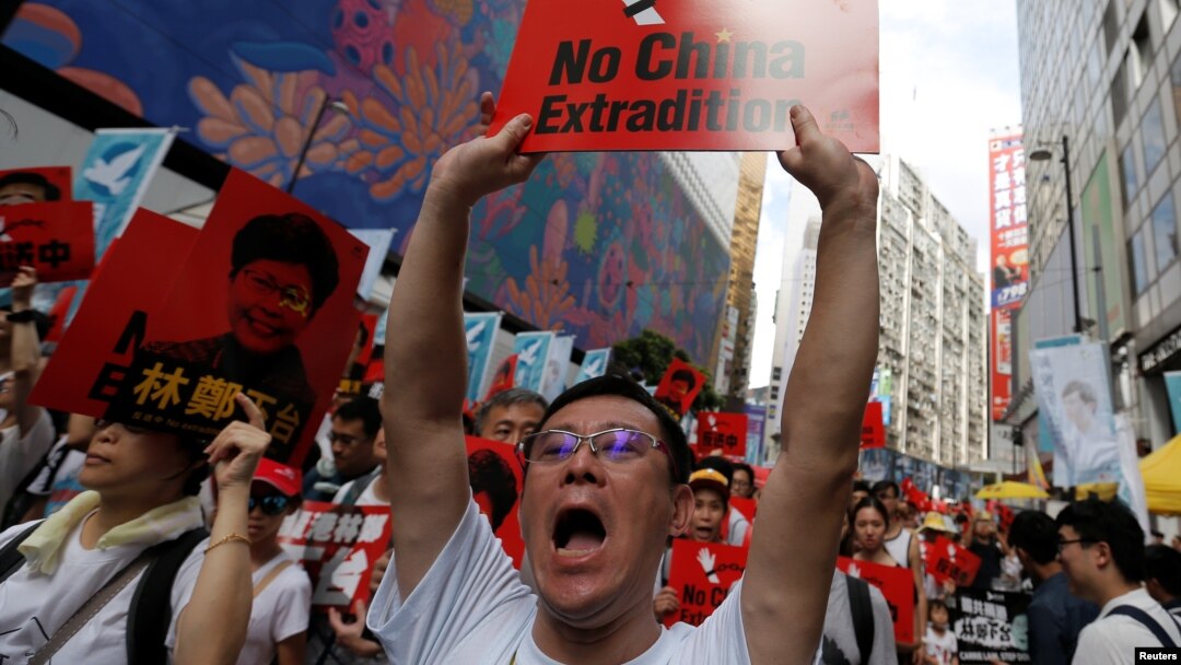 Seorang demonstran mengacungkan poster dalam unjuk rasa menuntut otoritas menghapus rancangan undang-undang ekstradisi dengan China, di Hong Kong, 9 Juni 2019.
