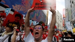 FILE - A demonstrator holds up a sign during a protest to demand authorities scrap a proposed extradition bill with China, in Hong Kong, China June 9, 2019.