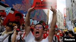 A demonstrator holds up a sign during a protest to demand authorities scrap a proposed extradition bill with China, in Hong Kong, China June 9, 2019.