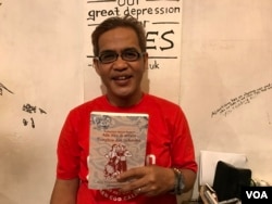 Aan Anshori menunjukkan buku "Ada Aku di antara Tionghoa dan Indonesia" yang dia inisiasi. Buku ini mengisahkan relasi antara orang Tionghoa dan etnis lain. (Foto: Rio Tuasikal/VOA)