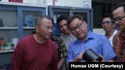 Ketua tim peneliti Yudi Utomo Imardjoko (baju biru) menunjukkan baterai nuklir hasil riset tim Universitas Gadjah Mada (UGM) kepada Dahlan Iskan. (Foto: Humas UGM)