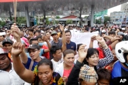 Cambodians shout slogans outside a shopping mall where prominent political analyst Kem Ley was shot dead in Phnom Penh, Cambodia, July 10, 2016.