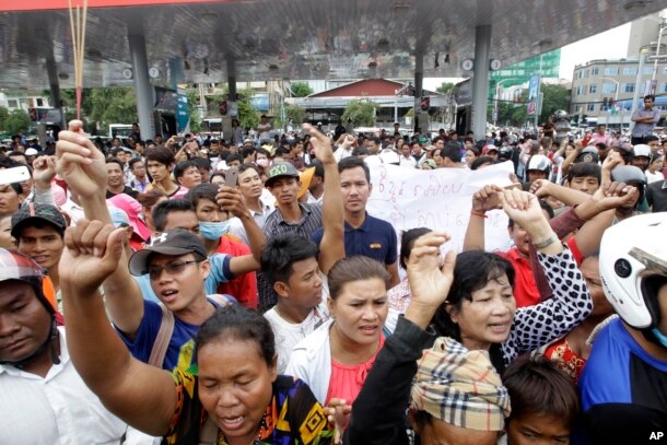 Cambodians shout slogans outside a shopping mall where prominent political analyst Kem Ley was shot dead in Phnom Penh, Cambodia, July 10, 2016.