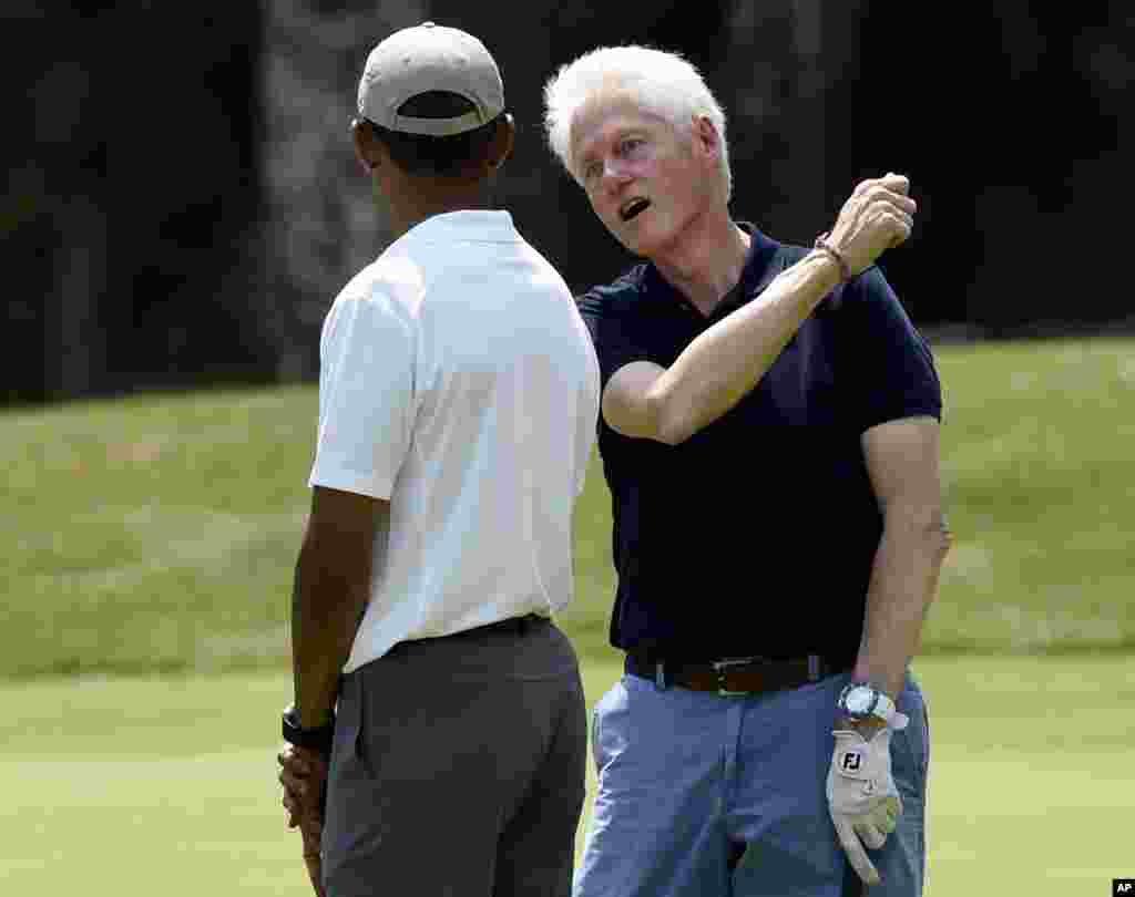 President Barack Obama, left, talks with former President Bill Clinton as they play golf on the first hole at Farm Neck Golf Club in Oak Bluffs, Massachusettes, on Martha&#39;s Vineyard, Aug. 15, 2015.
