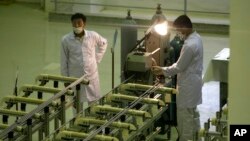 FILE - Iranian technicians work at a facility producing uranium fuel outside of Isfahan, 410 kilometers south of the capital, Tehran, April 9, 2009.