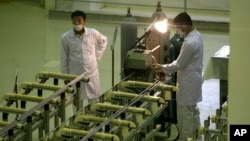 Iranian technicians work at a facility making uranium fuel in this file photo.