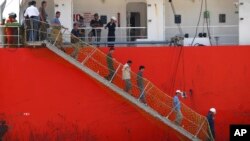 FILE - Afghan migrants walk down the stairway of a tanker that rescued them at a port in Cilegon, Banten province, Indonesia, Apr. 9, 2012. Indonesia said it had rescued 120 Afghan migrants from a leaking wooden ship headed to Australia after receiving a distress call from the ship's captain on Sunday and went to their aid. 