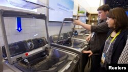 FILE - A couple examines a Samsung washing machine at the International Consumer Electronics Show (CES) in Las Vegas, Nevada, Jan. 6, 2015. 