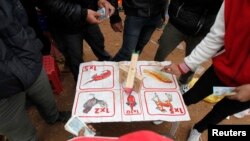 FILE - Residents place money during an illegal gambling activity at a village outside Hanoi, Feb. 12, 2014. Vietnam has been loosening rules on domestic gambling but lucrative, illegal operations have spurred a crackdown.