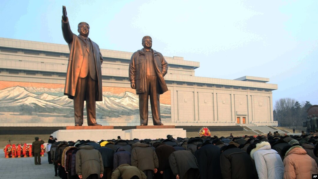 Warga menghormati patung-patung mendiang pemimpin Korea Utara, Kim Jong Il (kanan) dan ayahnya Kim Il Sung, di Pyongyang. (Foto: Dok)