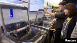 A couple examines a Samsung washing machine at the International Consumer Electronics Show (CES) in Las Vegas, Nevada.