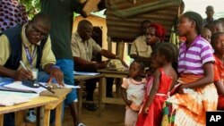 Government of Liberia Bureau of Immigration officials register asylum-seekers from Ivory Coast in the town of Loguatuo, in Nimba County