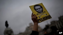 A man holds a sign with a portrait of Peru's jailed President Alberto Fujimori and the Spanish word "Danger" during a march in Lima, Peru, July 7, 2017. Peruvian President Pedro Kuczynski said Friday that a group of doctors will help him determine whether to release ex-president Alberto Fujimori, sentenced to 25 years prison, with a medical pardon.