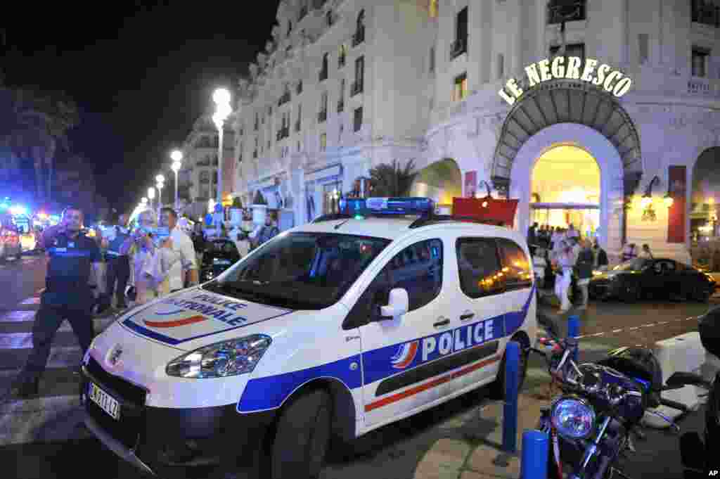 A police car is parked near the scene of an attack after a truck drove on to the sidewalk and plowed through a crowd of revelers who'd gathered to watch the fireworks in the French resort city of Nice, southern France, Friday, July 15, 2016.