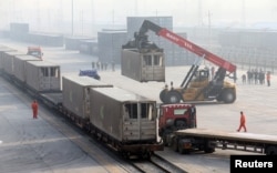 Workers unload containers from a train at Dahongmen Railway Station, Beijing, Jan. 14, 2019.
