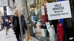 FILE - A shopper walks past a store with a help wanted sign in the window in New York, Oct. 1, 2015. The final major economic report of the Obama administration is expected to show continued modest economic growth.