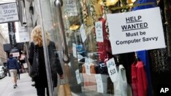 FILE - A shopper walks past a store with a help wanted sign in the window in New York, Oct. 1, 2015. The final major economic report of the Obama administration is expected to show continued modest economic growth.