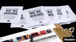 Des brochures affichant des offres d'emploi chez 'Gap Factory Store' sont distribuées lors d'une foire au Dolphin Mall à Miami, le mardi 6 octobre 2015.