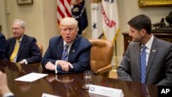 FILE - President Donald Trump, with Senate Majority Leader Mitch McConnell of Kentucky, left, and House Speaker Paul Ryan of Wisconsin, speaks during a meeting with congressional leaders in the Roosevelt Room of the White House in Washington, June 6, 2017