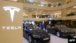 Tesla Model S (kiri) dan Model X (kanan) dipamerkan di sebuah pusat perbelanjaan di Hong Kong, 10 Maret 2019. (Foto: AFP)