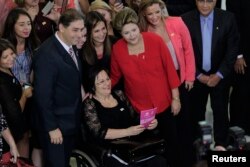 L'activiste Maria da Penha au milieu de femmes et d'hommes politiques, à Brasilia, le 13 mars 2013.