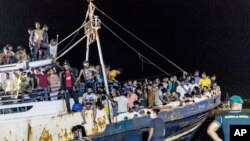 dengan para migran merapat di pelabuhan pulau Lampedusa Sisilia, Italia selatan, Senin, 27 September 2021. (Foto: AP)