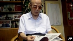 FILE - In this July 19, 2016, photo, Du Daozheng, 92, browses his Yanhuang Chunqiu magazine during an interview at his home in Beijing.