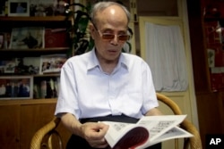 FILE - In this July 19, 2016, photo, Du Daozheng, 92, browses his Yanhuang Chunqiu magazine during an interview at his home in Beijing.