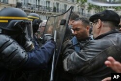 Protesters face riot police officers during a demonstration called by labor unions the day after the French presidential election, May 8, 2017.