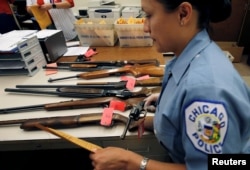 FILE - A Chicago Police officer prepares to inventory a hand gun turned in from the public as part of the "Gun Turn-in" event where a gift card is given for every firearm turned over to the police in Chicago, Illinois, May 28, 2016.