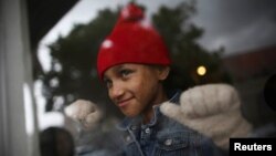 Ashley, 8, from Honduras and a member of a caravan of migrants from Central America, looks through the window of a restaurant near the San Ysidro checkpoint as the first fellow migrants entered U.S. territory to seek asylum, in Tijuana, Mexico, April 30, 2018.