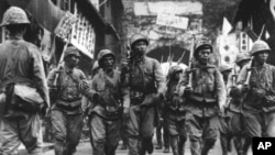 Binh sĩ Nhật Bản, với súng trên vai, đi trong thành phố cảng Ninh Ba trong vùng đông nam Trung Quốc, ngày 14 tháng 5 năm 1941