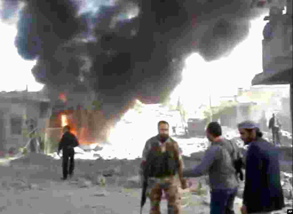 Syrians inspect damage and look for victims moments after an airstrike by Syrian warplanes in Ras al-Ayn, Syria, November 12, 2012, in an image taken from video.