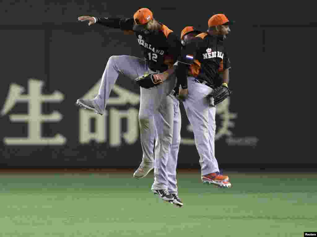 Netherlands&#39; Wladimir Balentien (R), Roger Bernadina (C) and Kalian Sams celebrate after defeating Cuba at the World Baseball Classic second round game in Tokyo, Japan. 