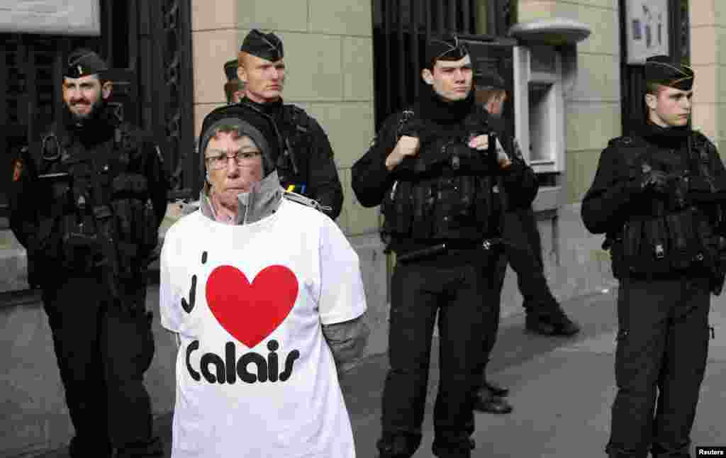 A resident of Calais stands in front of French police during a protest urging the government to help their failing businesses and restore the image of their port city affected by the migrant crisis, in Paris.