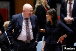 Russian Ambassador to the United Nations Vassily Nebenzya and United States Ambassador to the United Nations Nikki Haley speak before a United Nations Security Council meeting on the Crisis in the Middle East at the UN headquarters in New York, April 17, 2018.