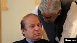 FILE - Former Pakistani Prime Minister Nawaz Sharif speaks with an official during a meeting in Islamabad, Aug. 9, 2017. 